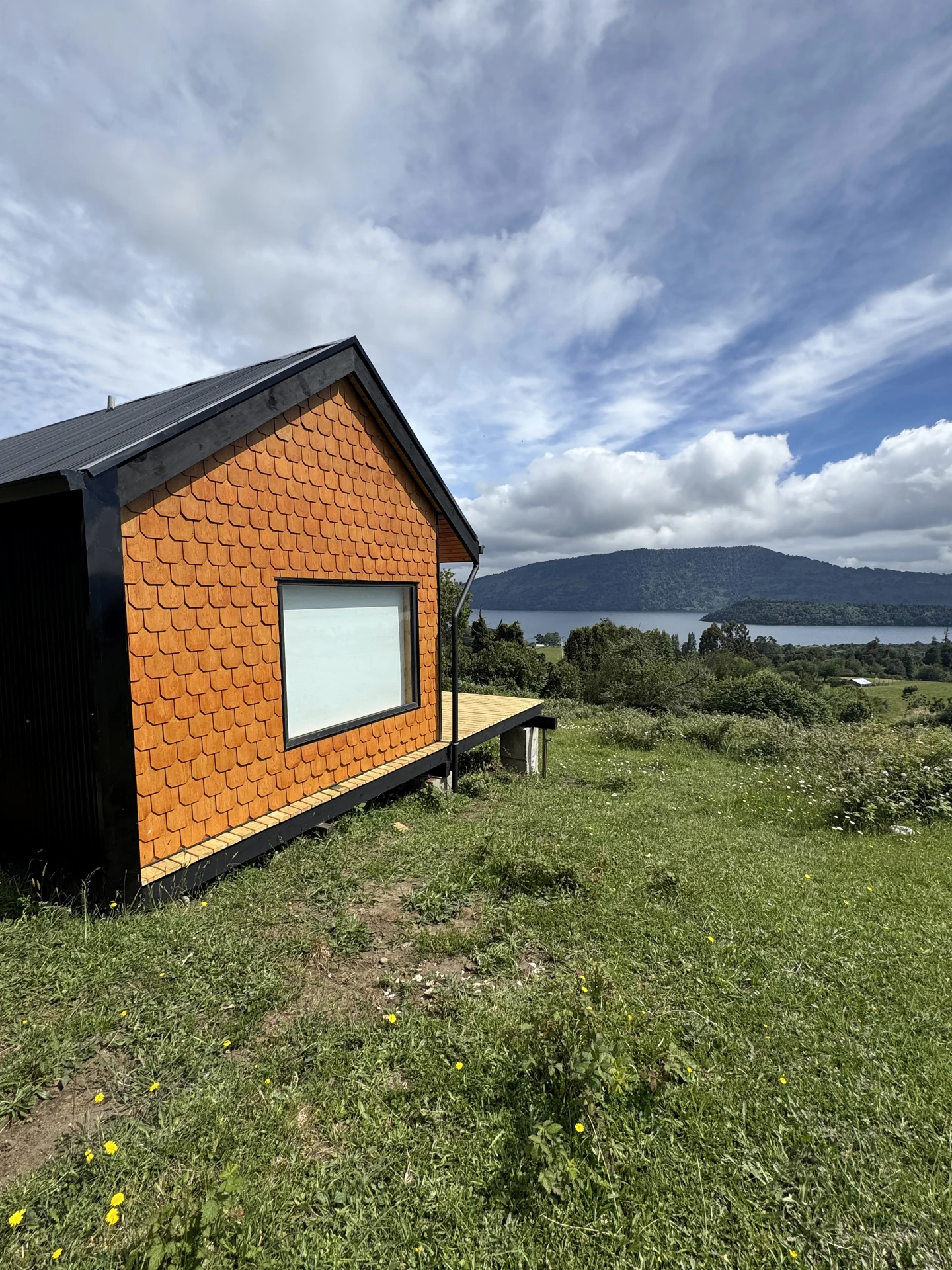 Exterior compacto de Cabaña Rupanco, con revestimiento de tejuela y cubierta inclinada.
