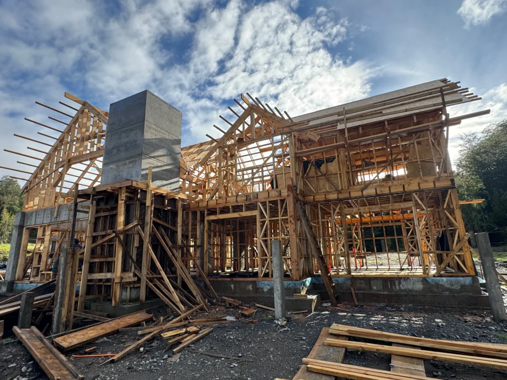 Estructura de madera y chimenea de Casa Sol en construcción.